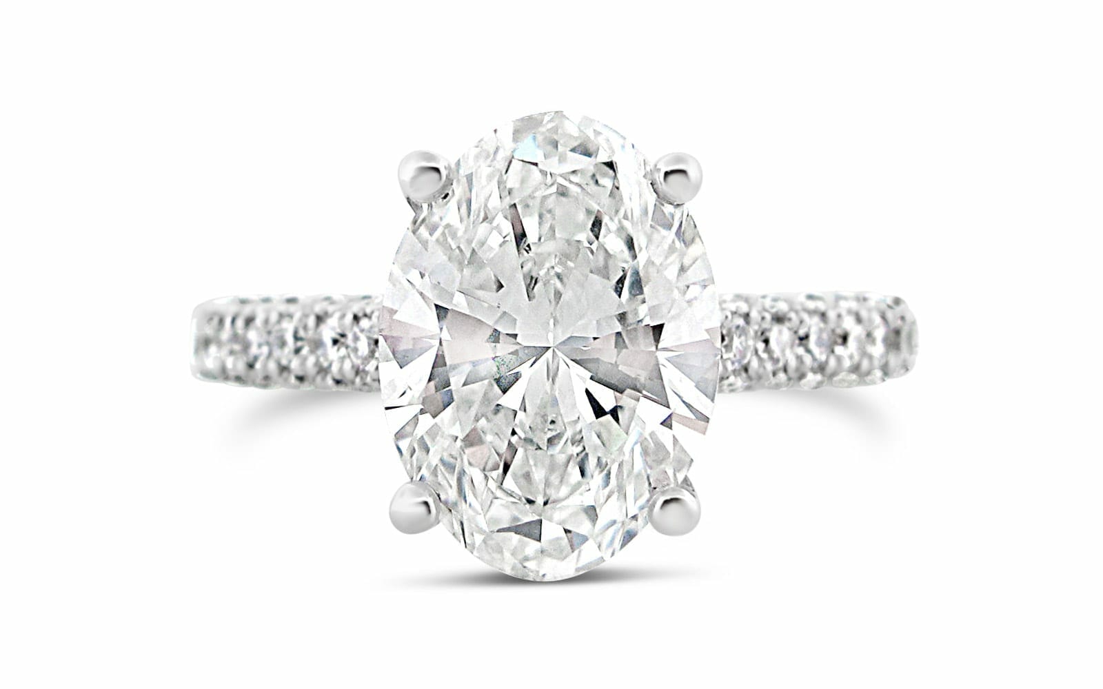 A diamond engagement ring with an oval cut center stone on the setting with smaller diamonds around the band.