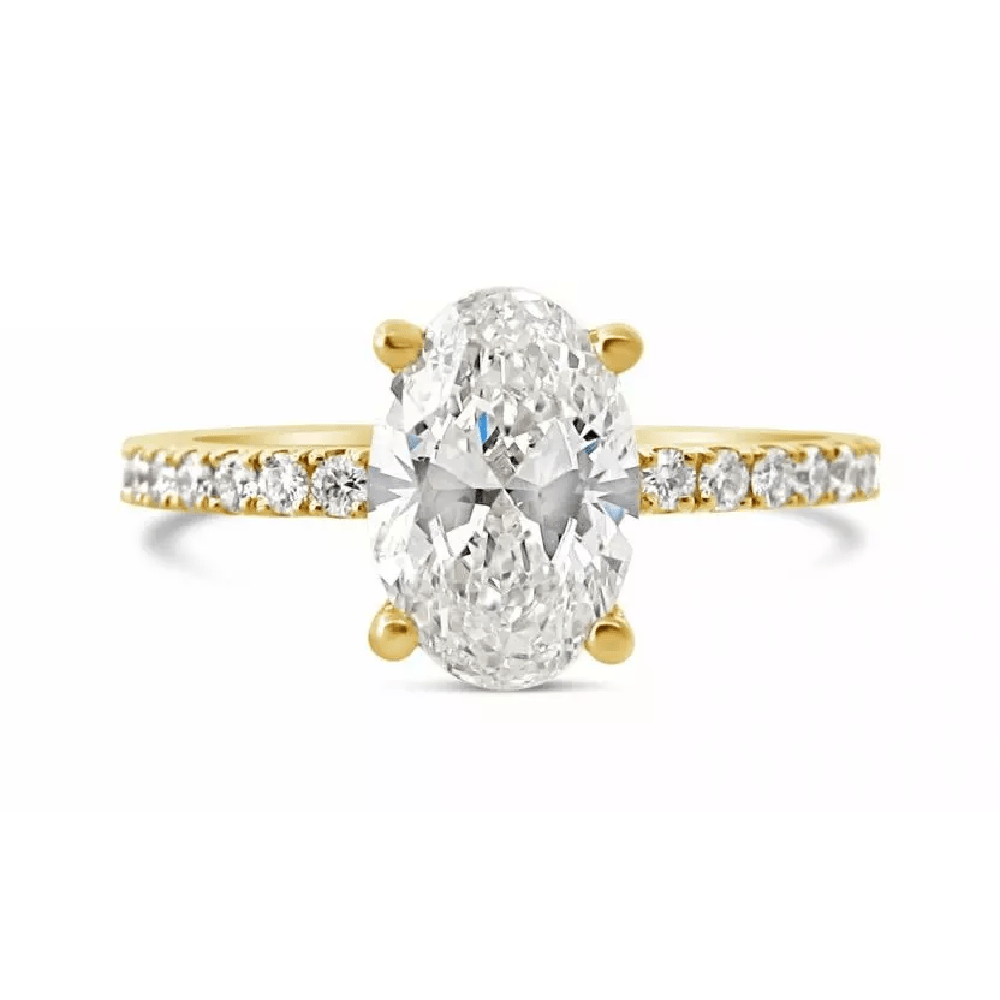 An oval cut custom diamond on a yellow gold band covered in round cut diamonds engagement ring.