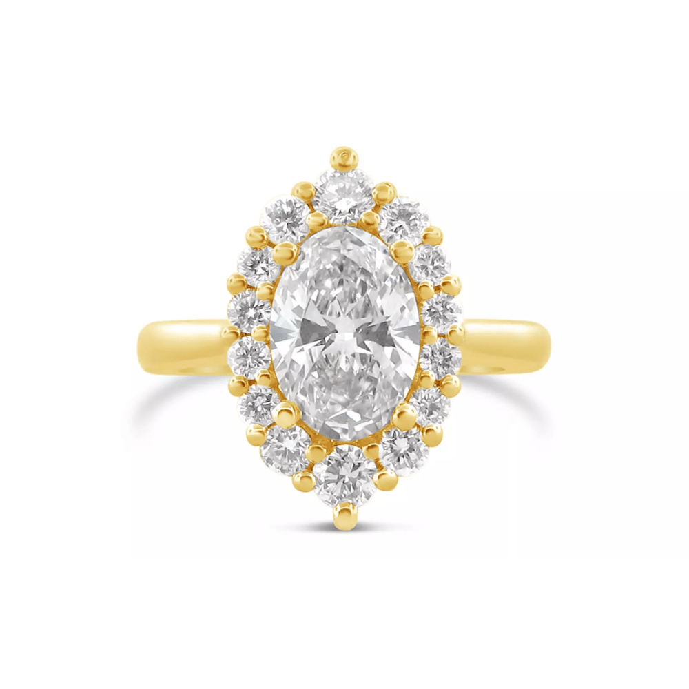 An oval cut diamond with slightly bigger diamonds on the ends, encircled by smaller diamonds that get smaller as they go around the oval, all on a yellow gold band.