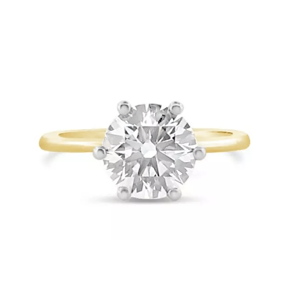 A simple round cut diamond on a yellow gold band engagement ring.