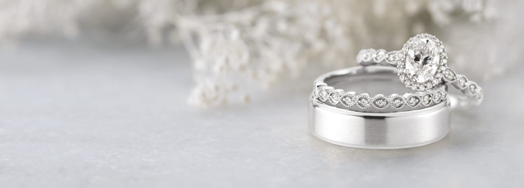 Ethically sourced engagement ring and wedding band sitting on the right of a decorated scene and table.