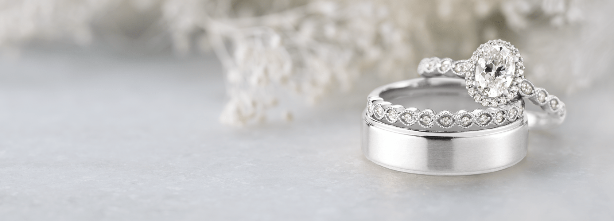 Ethically sourced engagement ring and wedding band sitting on the right of a decorated scene and table.