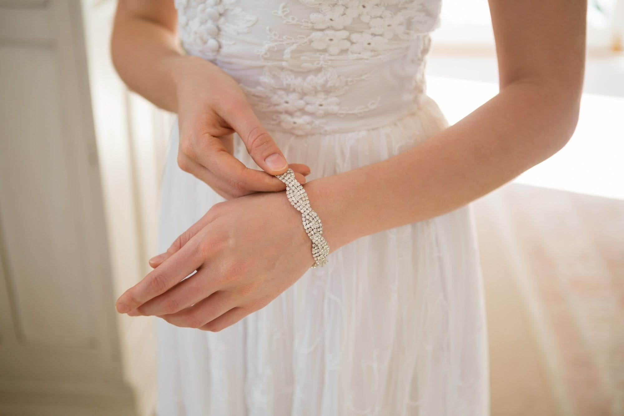 Midsection of bride wearing bracelet while standing at home